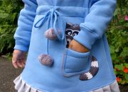 Ваша малышка с удовольствием будет носить его, ведь оно украшено милым енотом, выглядывающим из кармашка.
